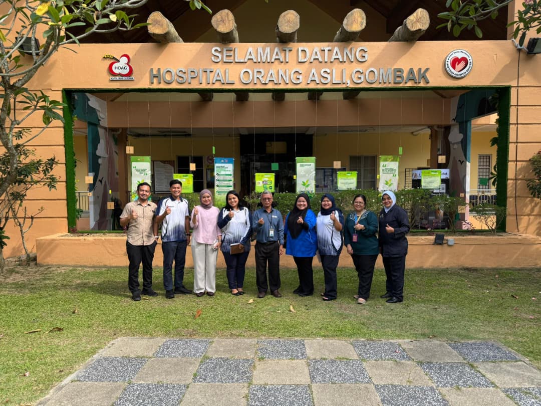 Group photo with thumbs up in front of the Hospital Orang Asli Gombak entrance