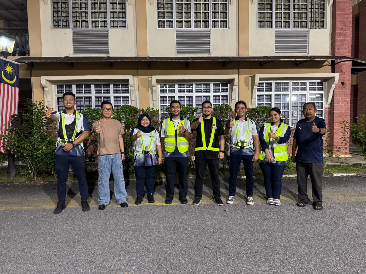 The commissioning team in safety vests giving a thumbs up at night